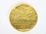 a gold coin with a picture of a ship on it