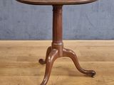 une vieille table en bois avec un plateau en bois, posée sur un parquet