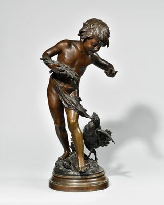 statue en bronze représentant un garçon avec un oiseau, posée sur un socle en marbre