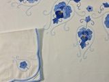 embroidered table cloth with blue flowers and vines on it