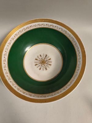 a green and gold plate with a snowflake on it