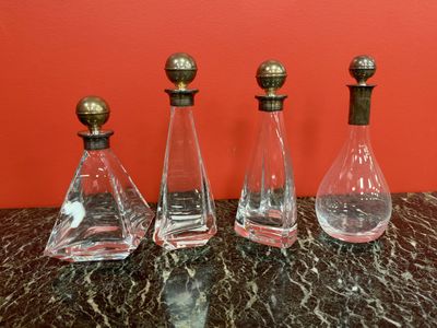 three glass decanters sitting on top of a marble table