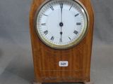 une petite horloge en bois avec des chiffres romains