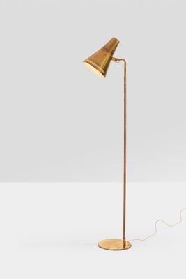 a brass floor lamp with a wooden base and a brass shade