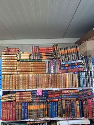 a large pile of books on a shelf in a room