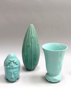 three vases and a vase on a white surface with a gray background