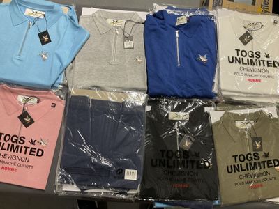un grand nombre de t-shirts posés sur une table