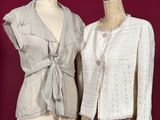 two mannequins with jackets on display on a stand