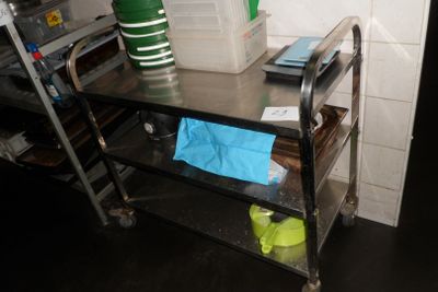 une photo d'une cuisine avec une table en métal et une étagère en métal