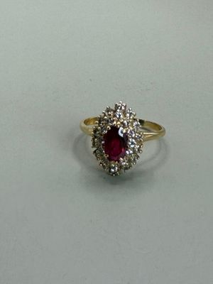a picture of a ring with a ruby and diamond center