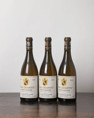 trois bouteilles de vin posées sur une table en bois