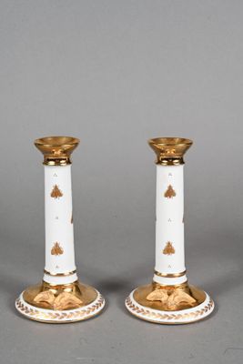 pair of white and gold candlesticks with floral decoration
