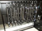 a bunch of guns hanging on a rack in a room