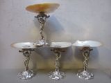 trois bougeoirs en argent et nacre posés sur une table