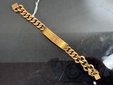 bracelet plaqué or présenté dans une vitrine sur fond noir