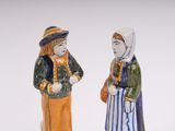 pair of ceramic figurines of two women in traditional clothing