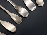 five spoons and two spoons sitting on a table