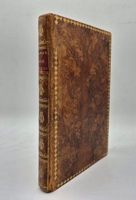 un vieux livre à la couverture brune posé sur une surface blanche