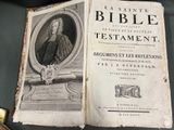 an old book sitting on top of a table next to a pen