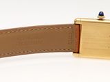 an image of a watch with a gold case and brown leather strap