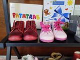 many pairs of baby shoes on a shelf next to books