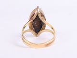 a close up of a gold ring with a brown stone in it