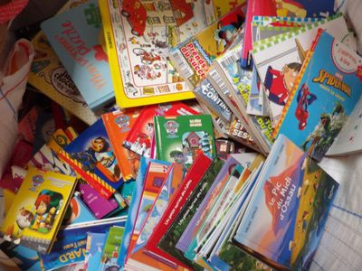 many children ' s books in a box on the bed