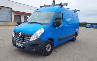 La camionnette bleue est garée sur un parking près d'un immeuble.