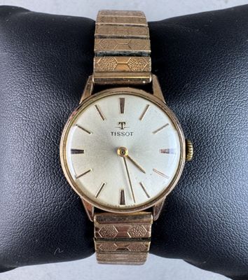 a close up of a watch on a wrist on a display case
