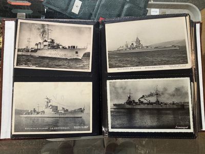 plusieurs photos en noir et blanc de navires, rangées dans un coffret posé sur une table