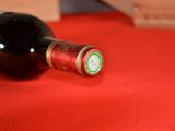 a bottle of wine sitting on a red table cloth