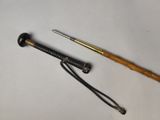 a close up of a knife and a cane on a white surface