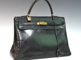 an image of a black and green leather handbag on a white surface
