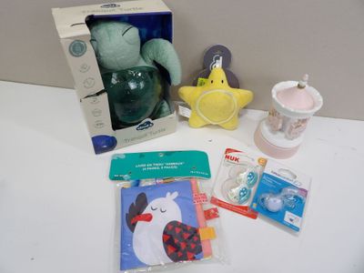 une peluche, une tétine, une brosse à dents, un dentifrice, un porte-dentifrice et d'autres objets posés sur une table
