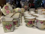 many cups and saucers sitting on a table