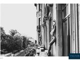 photographie en noir et blanc d'une femme adossée à un immeuble