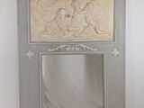 a mirror in the corner of a room with a painting on it