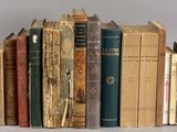 a lot of old books that are on a shelf