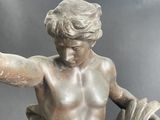 a statue of a boy holding a bowl of fruit