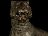 bronze statue of a dog with open mouth on a black background