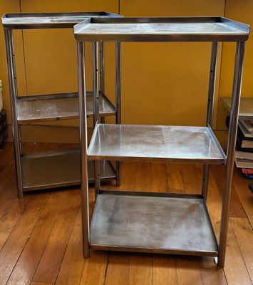 une table en métal avec deux étagères, dans une pièce