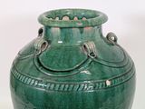 a large green vase with two handles on it