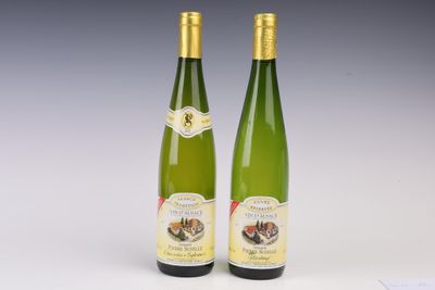 two bottles of white wine sitting next to each other on a table