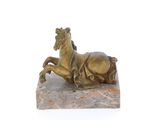 statue d'un cheval couché sur un rocher, sur fond blanc