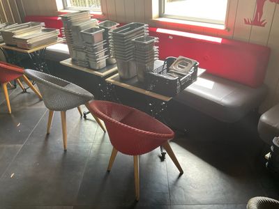 plusieurs chaises et une table dans une pièce où se trouvent de nombreux livres posés dessus