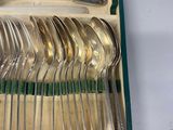 a lot of silver spoons and forks in a box