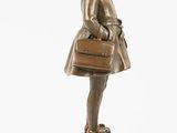 bronze figurine of a girl with a suitcase and a hat