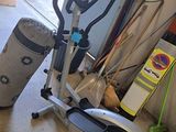 a stationary exercise bike in a garage next to a trash can