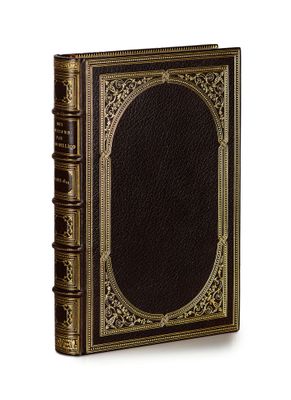an old book with gold trim and a black cover