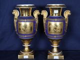 une paire de vases dorés et bleus ornés de représentations d'hommes et de femmes